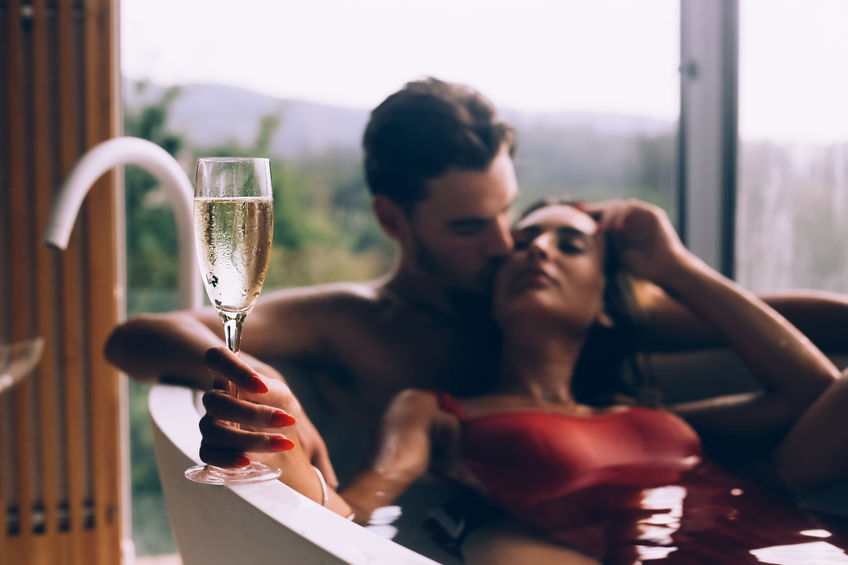 couple qui se détend dans la baignoire avec champagne