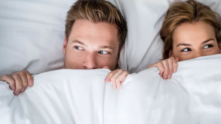 Couple sous la couette prêt pour leur week-end coquin