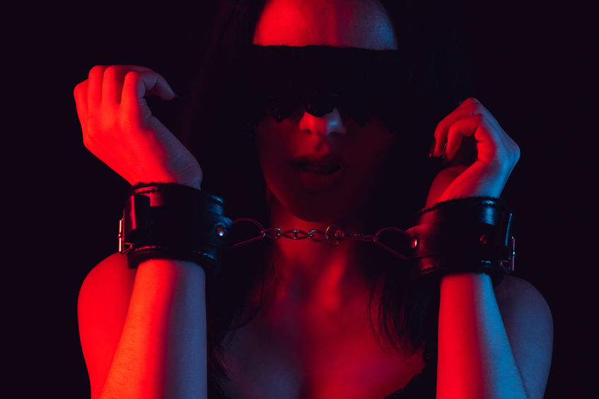 face of sexy girl with lace blindfold and leather bdsm handcuffs